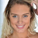 Gorgeous blonde Athena reveals her perfect melons and poses nude on a chair