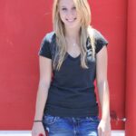 Cute blonde babe Alanna unveils her small boobs and poses nude outdoors
