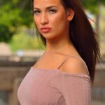 Sensual brunette Olivia hikes her dress up and toys her anal hole in public