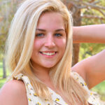 Blonde amateur exposes her firm boobs during a walk in the park