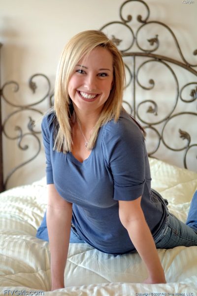 Glamour babe with a beautiful smile Kaitlyn toys her shaved pussy on her bed Image #1